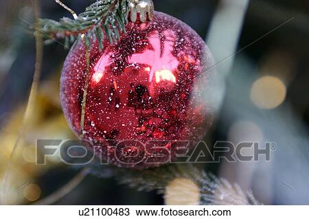 Stock Image - Christmas ornaments on evergreen tree, with reflection of Italian architecture in red metallic ball. Fotosearch