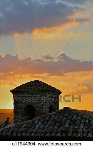 Picture - Church tower and roof tiles close up, with sunset sky, Umbria Italy. Fotosearch