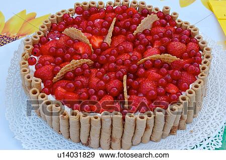 Stock Photo - Closeup of fruit pie with palisade of rolled wafers surrounding and red currant and strawberry centre. Fotosearch