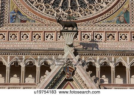 Closeup of part of Rose window, ornate sculpture and decoration of facade of Orvieto Duomo, with central bronze ram statue View Large Photo Image Stock Image - Closeup of part of Rose window, ornate sculpture and decoration of facade of Orvieto Duomo, with central bronze ram statue. Fotosearch