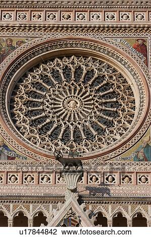 Stock Image - Closeup of Rose window, ornate sculpture and decoration of facade of Orvieto Duomo. Fotosearch
