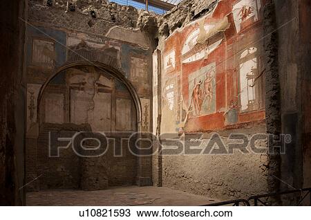 Stock Image - Cyclists seen from under arched portico, in front of Cattedrale (Loggia del Mercato) on cobble stone street, with Campanile, . Fotosearch