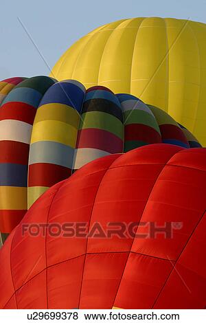 Stock Photo - Detail of 3 hot air balloons on ground, one red, one yellow and one multi-coloured. Fotosearch