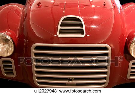 Stock Photo - Detail of antique red Ferrari, front view, with silver grille and headlamps. Fotosearch