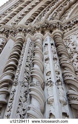 Stock Image - detail of exterior facade of San Fortunato church, Todi, showing ornate twisted sculpture stone columns around central doorway. Fotosearch