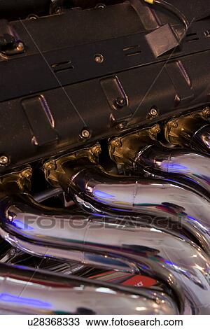Stock Image - Detail of Ferrari engine, showing exhaust manifold. Fotosearch