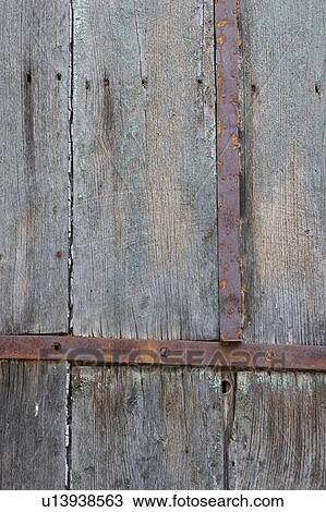 Stock Image - Detail of old Italian weathered wooden plank door. Fotosearch