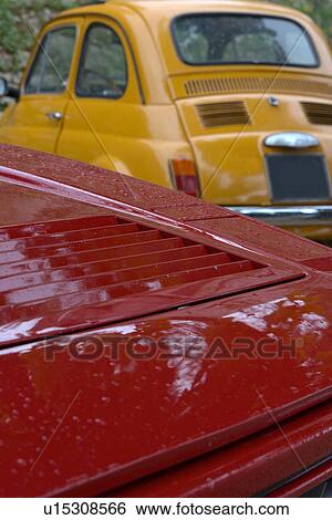 Detail of parked red Ferrari, with yellow Fiat cinquecento, on cloudy rainy day View Large Photo Image Stock Photograph - Detail of parked red Ferrari, with yellow Fiat cinquecento, on cloudy rainy day. Fotosearch