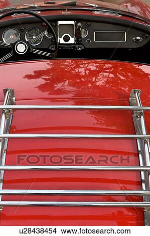 Detail of rear MG red convertible, showing luggage rack, steering wheel and dash View Large Photo Image Picture - Detail of rear MG red convertible, showing luggage rack, steering wheel and dash. Fotosearch