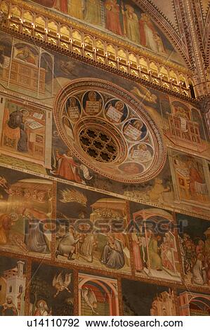 Stock Image - detail of side wall of apse frescoes and illuminated balcony, with central rosette window. Fotosearch