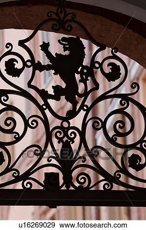 Stock Photo - Detail of wrought iron decoration, with lion rampant, over entrance to Italian palace courtyard. Fotosearch