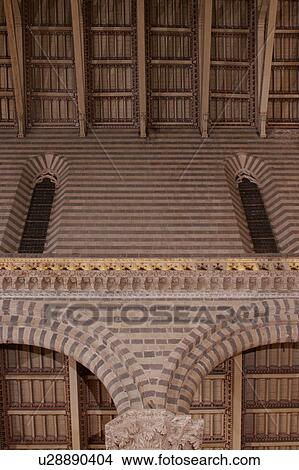 Picture - Detail view of side nave of Orvieto Duomo, showing black and white striped columns, arches, wooden sloped ceiling. Fotosearch