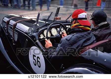 Stock Image - Driver and navigator in vintage car race, Mille Miglia, Orvieto, Italy. Fotosearch