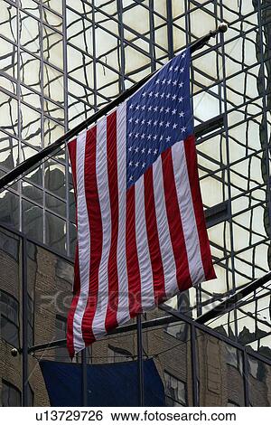 Stock Photograph - East 42nd Street, U. S. Flag reflected in glass windows. Fotosearch