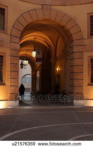 Ferrara Theatre inner courtyard, illuminated circular building, with cyclist and parked bicycles, Castello Estense in background View Large Photo Image Stock Photo - Ferrara Theatre inner courtyard, illuminated circular building, with cyclist and parked bicycles, Castello Estense in background. Fotosearch