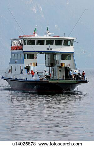 Ferry boat crossing Lake Como with car on deck, passengers, and mountains in background View Large Photo Image Stock Photo - Ferry boat crossing Lake Como with car on deck, passengers, and mountains in background. Fotosearch