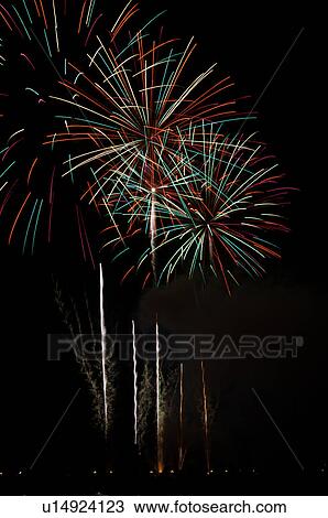 Stock Image - Fireworks exploding in the black night sky. Fotosearch