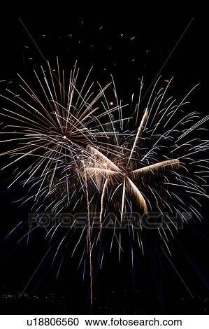 Stock Image - Fireworks exploding in the black night sky. Fotosearch