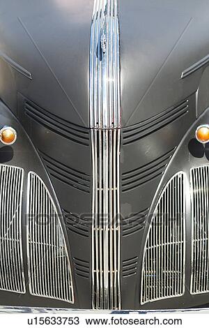Stock Image - Front view detail of antique grey car with silver grille details. Fotosearch