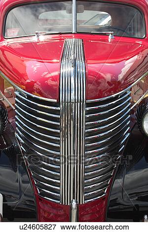 Stock Photo - Front view detail of antique red car with silver grille, hood and windscreen detail. Fotosearch