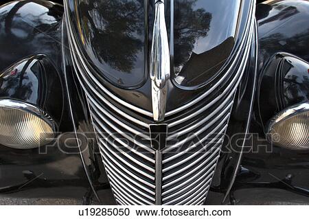 Stock Image - Front view detail of black Fiat showing hood, headlamps, and grille. Fotosearch