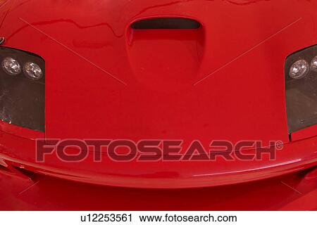 Stock Image - Front view detail of red Ferrari, aerial view of hood with headlamps. Fotosearch