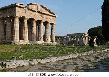 Greek Temples in Campania, Italy: Paestum - Roman road (Cardus Maximus) and Temple of Neptune (Poseidon) aka Temple of Hera II, Background - Basilica aka Temple of Hera I, front facade View Large Photo Image Stock Photo - Greek Temples in Campania, Italy: Paestum - Roman road (Cardus Maximus) and Temple of Neptune (Poseidon) aka Temple of Hera II, Background - Basilica aka Temple of Hera I, front facade. Fotosearch