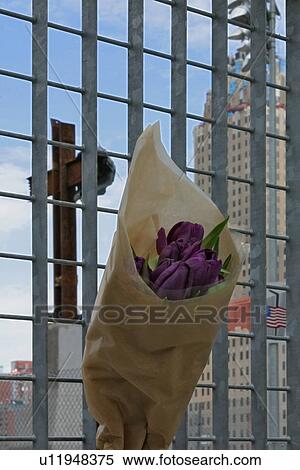 Ground Zero Memorial -bunch of flowers hanging on metal grille with cross and skyscrapers behind View Large Photo Image Stock Photography - Ground Zero Memorial -bunch of flowers hanging on metal grille with cross and skyscrapers behind. Fotosearch