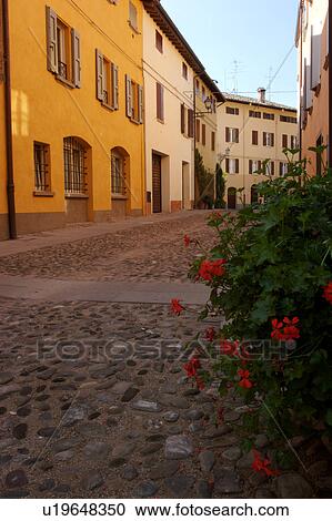 Stock Image - Historic centre of Castelvetro di Modena, cobbled street and restored Gothic houses. Fotosearch