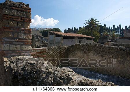 In the shadow of Vesuvius, the ruins of Ercolano - the Inn house, with modern town behind View Large Photo Image Stock Image - In the shadow of Vesuvius, the ruins of Ercolano - the Inn house, with modern town behind. Fotosearch