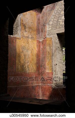 Stock Image - In the shadow of Vesuvius, the ruins of the Imperial Villa of Oplontis - detail of frescoes in guest rooms with architectural detail of window frame. Fotosearch