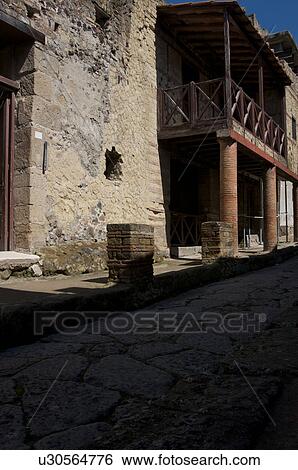 In the shadow of Vesuvius, the ruins of Ercolano - view of ancient road and Trellis house View Large Photo Image Stock Photograph - In the shadow of Vesuvius, the ruins of Ercolano - view of ancient road and Trellis house. Fotosearch