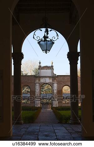 Inner courtyard of palazzo Diamante, with ornamental landscaped garden beyond arched entrance with columns, wrought iron lamp above View Large Photo Image Stock Photo - Inner courtyard of palazzo Diamante, with ornamental landscaped garden beyond arched entrance with columns, wrought iron lamp above. Fotosearch