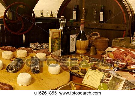 Stock Photography - Interior of Italian cantina with spread of local produce, cheeses, truffle, prosciutto, ham oil and wine, with oil and wine making implements. Fotosearch