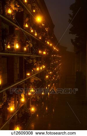 Italian cemetery with rows of flowers at tombs, night view in fog, with lights lit and reflected in wet paving View Large Photo Image Stock Photo - Italian cemetery with rows of flowers at tombs, night view in fog, with lights lit and reflected in wet paving. Fotosearch