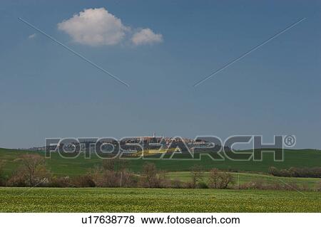 landscape view of Pienza across green fields, yellow flowers, with blue sky in spring time View Large Photo Image Stock Photo - landscape view of Pienza across green fields, yellow flowers, with blue sky in spring time. Fotosearch
