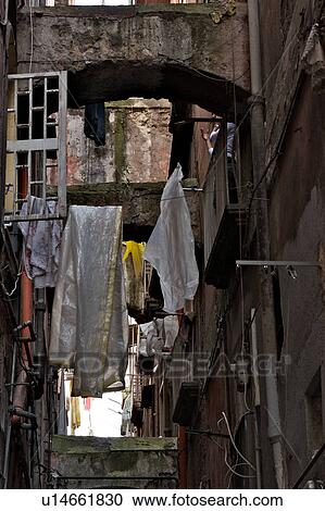 Stock Image - Naples street detail with laundry hanging, open window and street arch. Fotosearch