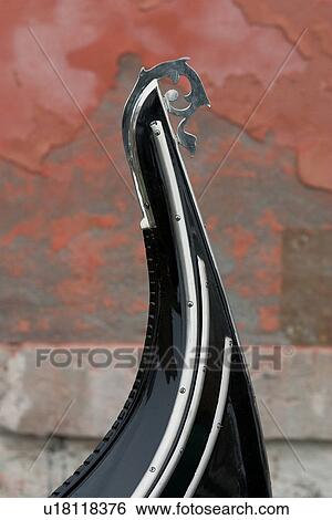 Stock Photograph - Ornamental bow of gondola with pink stone wall in background. Fotosearch