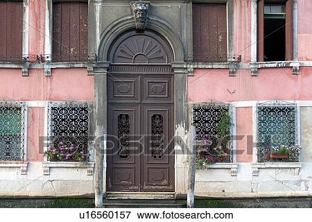 Stock Photo - Palazzo entrance from canal, showing entrance, iron grilles, windows with brown shutters. Fotosearch