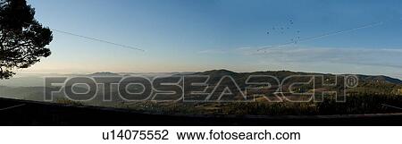 Panoramic view of Tiber Valley and outline of Todi, from Piazza, Montecastello di Vibio, sunrise with early morning mist, flock of birds in blue sky View Large Photo Image Stock Image - Panoramic view of Tiber Valley and outline of Todi, from Piazza, Montecastello di Vibio, sunrise with early morning mist, flock of birds in blue sky. Fotosearch