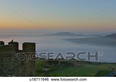 pigeons silhouetted on medieval tower, with Todi in distance, in early morning fog MonteCastello di Vibio, Umbria, Italy View Large Photo Image Stock Photograph - pigeons silhouetted on medieval tower, with Todi in distance, in early morning fog MonteCastello di Vibio, Umbria, Italy. Fotosearch