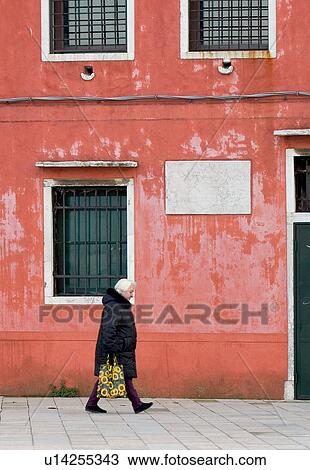 pink coloured building, person walking along edge of canal, winter coat and flower-decorated shopping bag View Large Photo Image Stock Image - pink coloured building, person walking along edge of canal, winter coat and flower-decorated shopping bag. Fotosearch