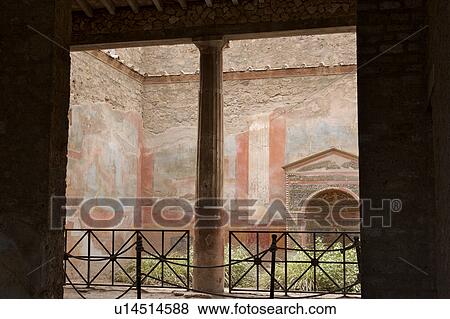 Stock Photo - Pompeii - House of the Small Fountain, view of lararium, fresco on walls, column, iron railing and entrance. Fotosearch