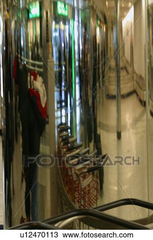 Reflection of luggage trolleys and passenger in mirror column, airport baggage collection area View Large Photo Image Stock Image - Reflection of luggage trolleys and passenger in mirror column, airport baggage collection area. Fotosearch
