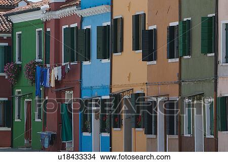 Row of different coloured brightly painted houses, all with green window shutters, Burano, Venice View Large Photo Image Picture - Row of different coloured brightly painted houses, all with green window shutters, Burano, Venice. Fotosearch