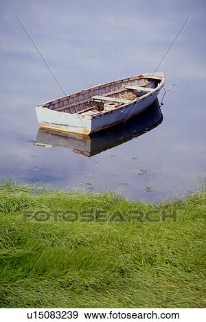 Rowing boat anchored in water, with reflection of blue sky in water, grassy embankment View Large Photo Image Stock Photo - Rowing boat anchored in water, with reflection of blue sky in water, grassy embankment . Fotosearch