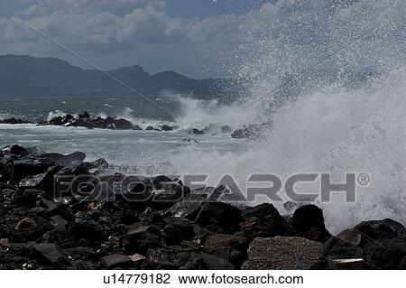 Sea surf breaking on rocks with blue sky, sea, and mountains in distance View Large Photo Image Stock Image - Sea surf breaking on rocks with blue sky, sea, and mountains in distance. Fotosearch