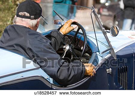 Stock Photo - Side view of antique blue car with driver, steering wheel. Fotosearch