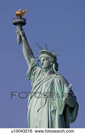 Statue of Liberty, detail from front, left, oblique side against blue sky View Large Photo Image Stock Photograph - Statue of Liberty, detail from front, left, oblique side against blue sky. Fotosearch