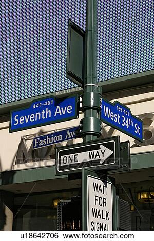 Stock Photograph - Street sign 7th and 34th Street, with multicoloured electronic sign (digital light panel display) in background. Fotosearch